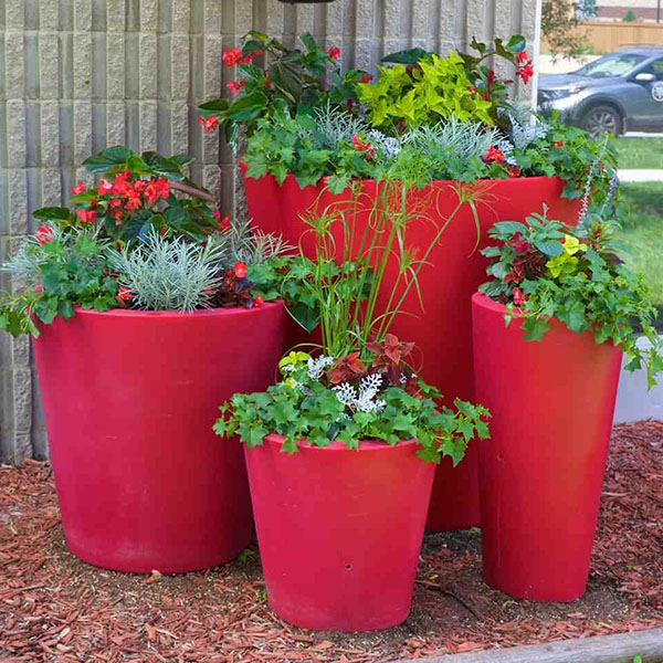 Decorative commercial self-watering planters with mixed greenery and flowers for low-maintenance landscape design.